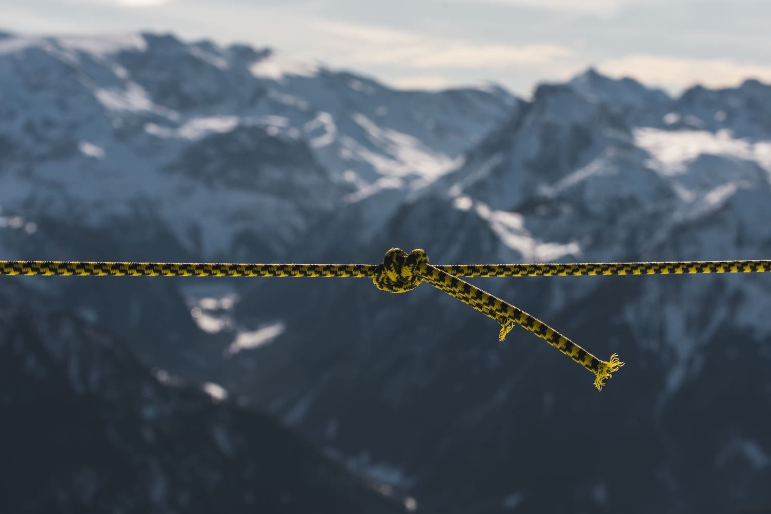 closeup_shot_twisted_rope_front_mountains_covered_snow.jpg